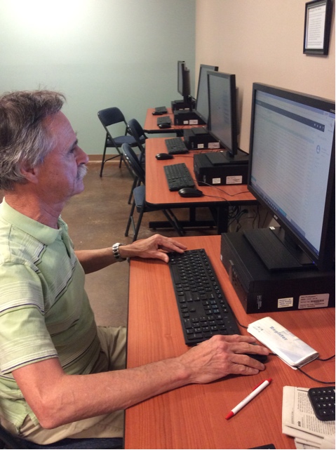 Hombre usando una computadora, con otras computadoras de fondo.