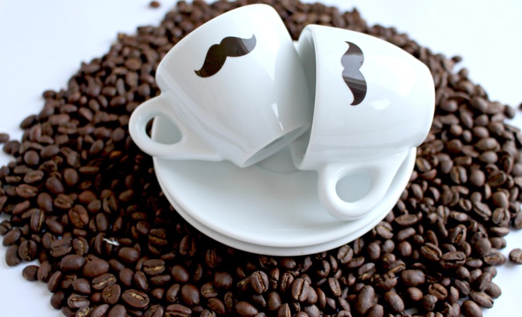 Coffee mugs with mustaches and coffee beans.