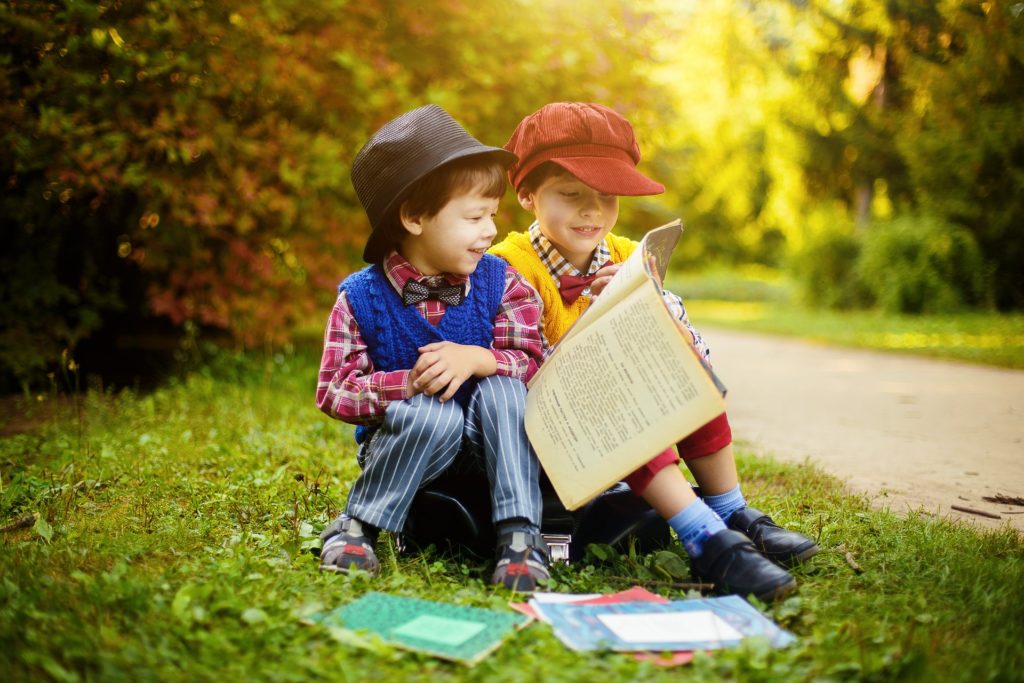 Niños leyendo al aire libre.