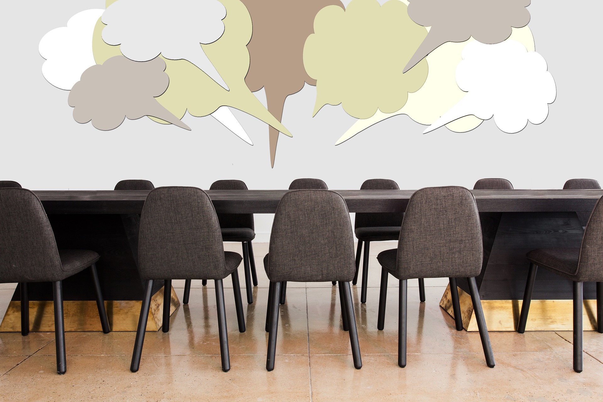 Conference table and chairs with speech bubbles.