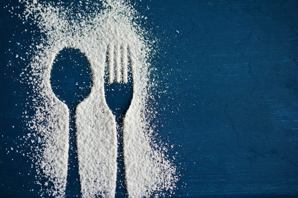 Outline of fork and spoon in white powder.