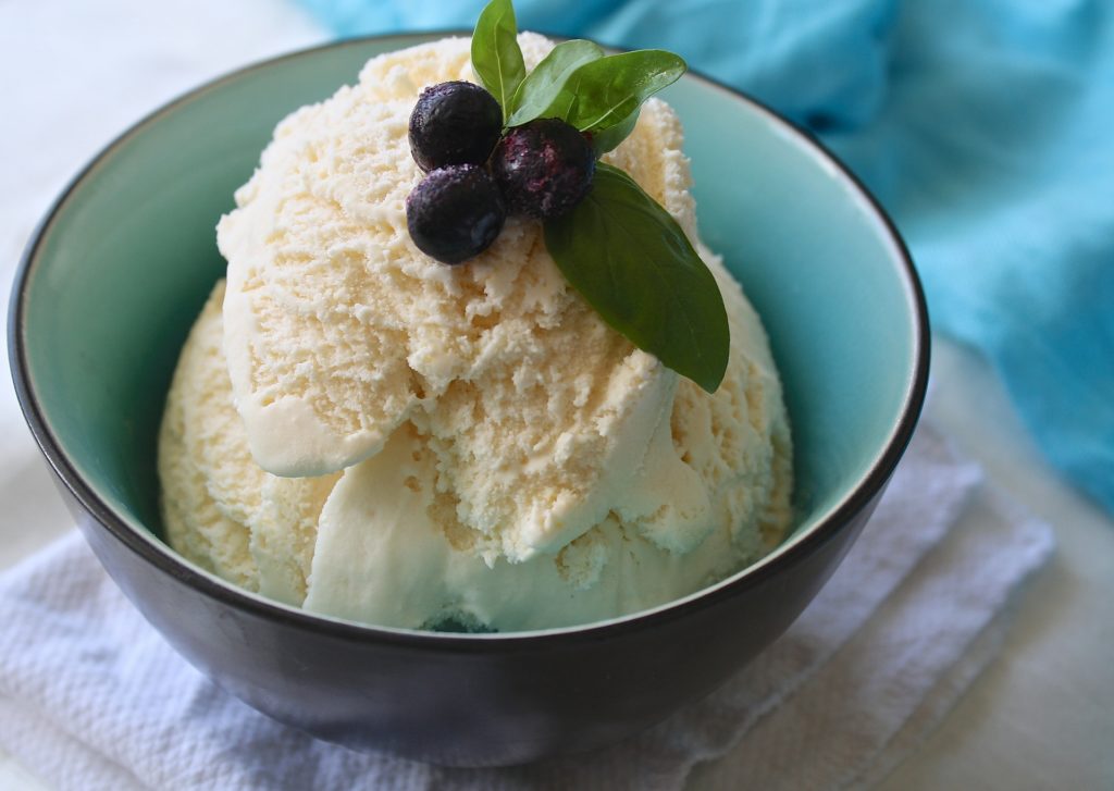 Ice cream in a bowl with blue berries on top.